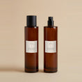 Load image into Gallery viewer, Cranberry & Orange room spray 100ml, two amber glass bottles side by side, one capped and one showing the fine mist atomiser