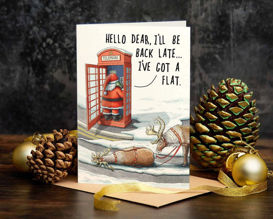 Christmas card reading 'Hello dear, I'll be back late, I've got a flat', with Santa in a red telephone box and a reindeer on its back beside the sleigh
