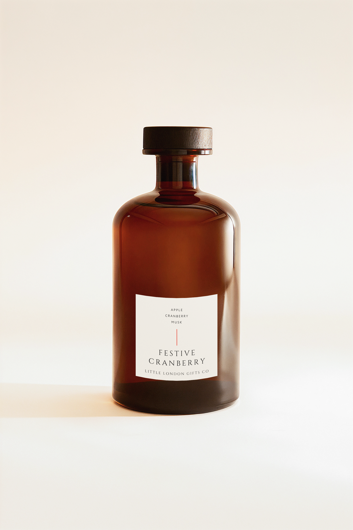 Festive Cranberry diffuser bottle in amber glass with a cream label, shown without its reeds