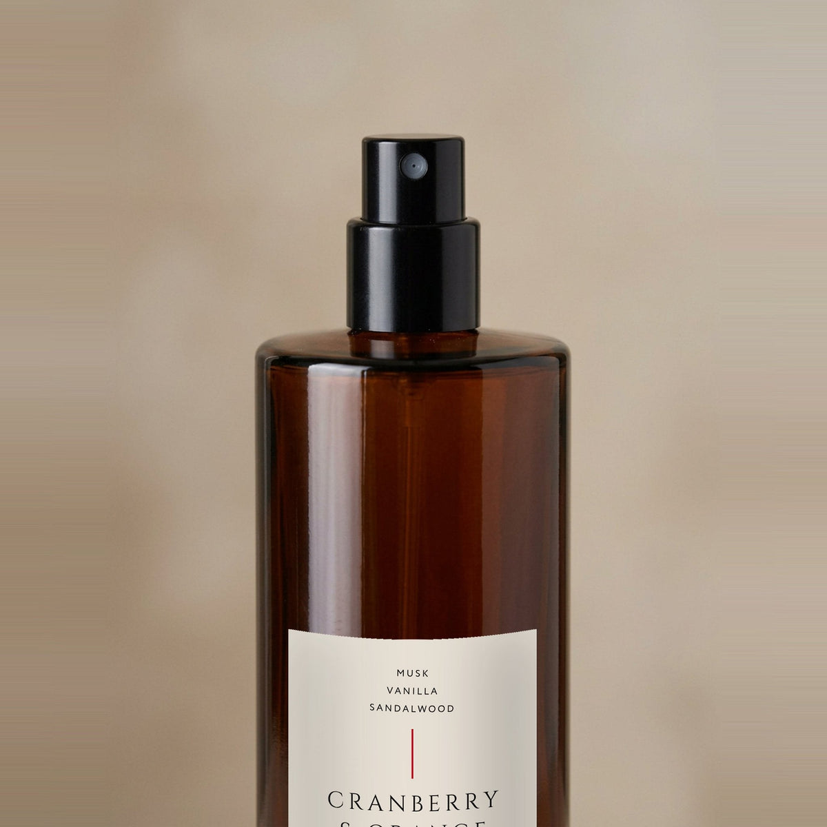 Close-up of the Cranberry & Orange room spray 100ml fine mist atomiser and amber glass bottle, Little London Gifts Co