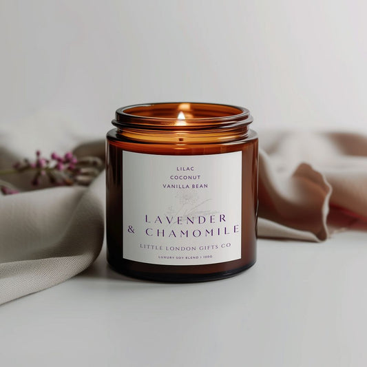 Lavender & Chamomile candle in amber glass beside dried flowers on a pale surface