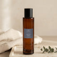 Load image into Gallery viewer, Orchid Noir room spray 100ml, amber glass bottle on a marble tray with linen and eucalyptus
