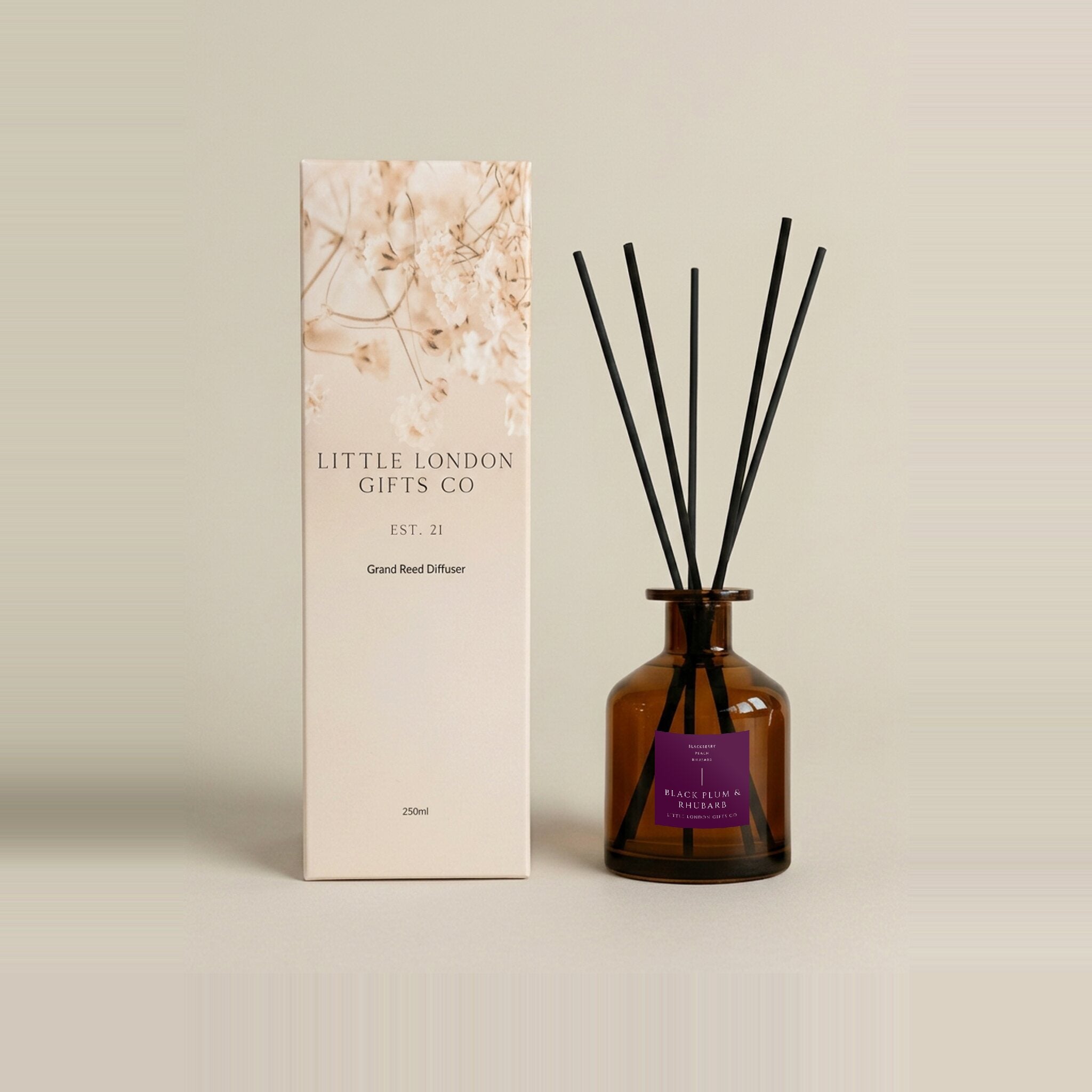 Plum & Rhubarb 250ml reed diffuser, amber glass bottle with a deep purple label and black reeds beside its gift box
