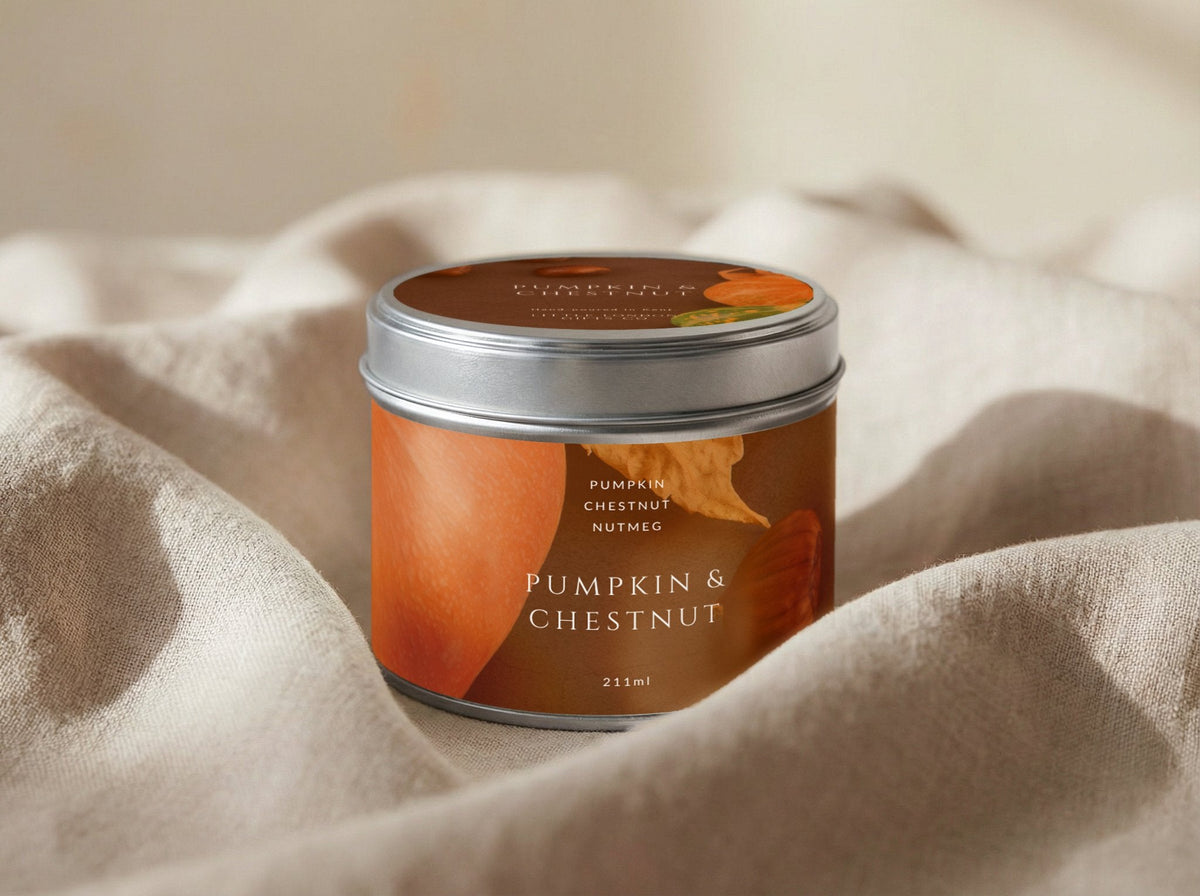 Pumpkin & Chestnut candle tin 211ml with the lid on, resting on draped cream linen