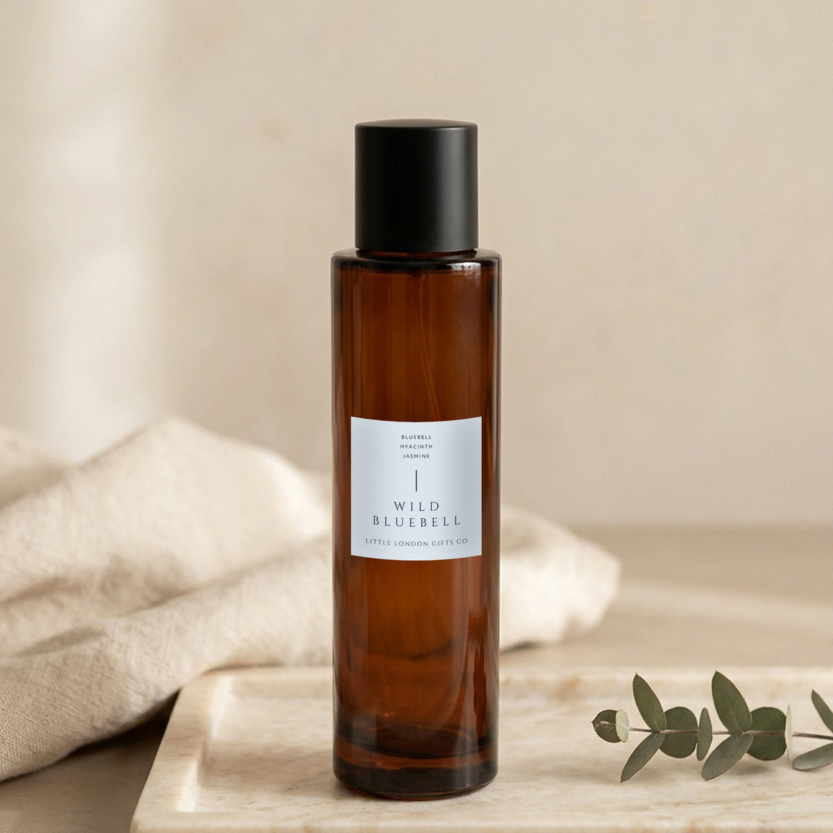 English Bluebell room spray 100ml, amber glass bottle on a marble tray with linen and eucalyptus